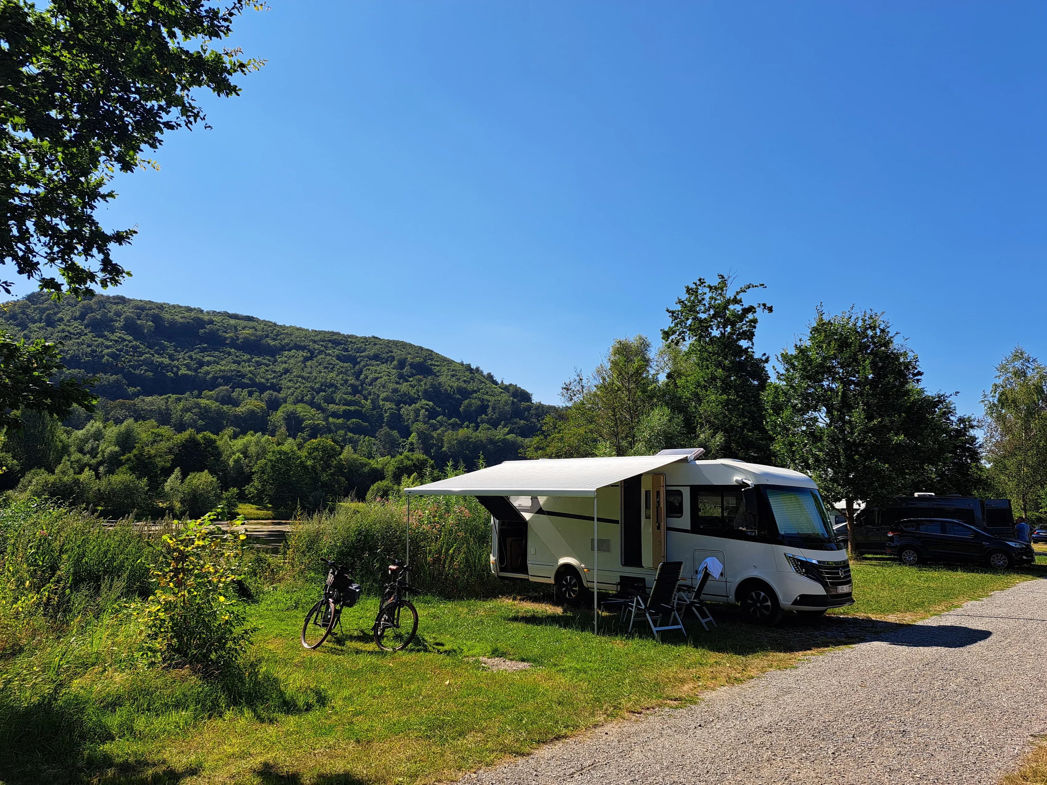 Wohnmobil auf einer Rasenfläche, dahinter der Axelsee